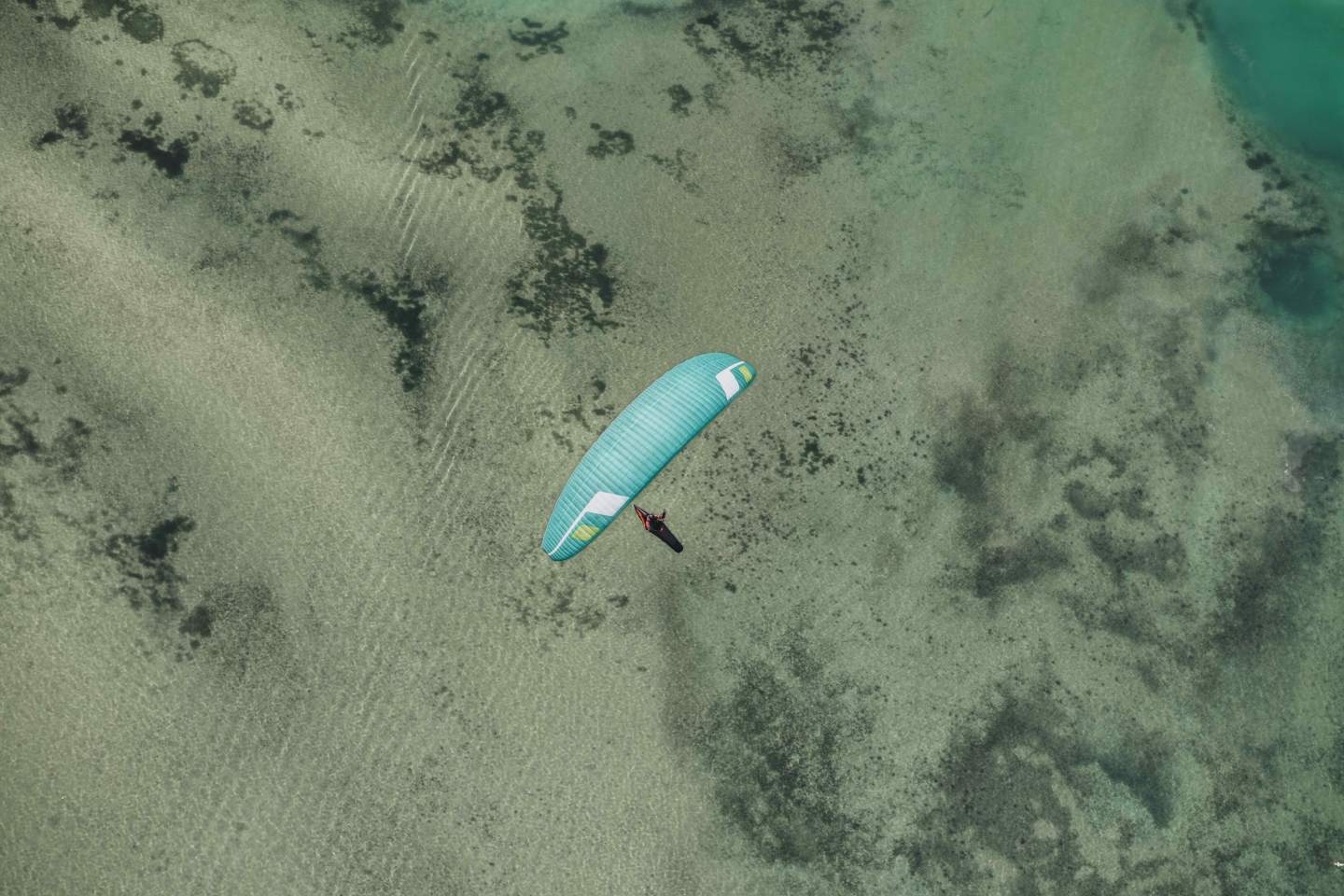 Parapentiste en fin de montée sur une crête d’altitude, voile encore dans le sac, s’apprêtant à préparer son décollage.