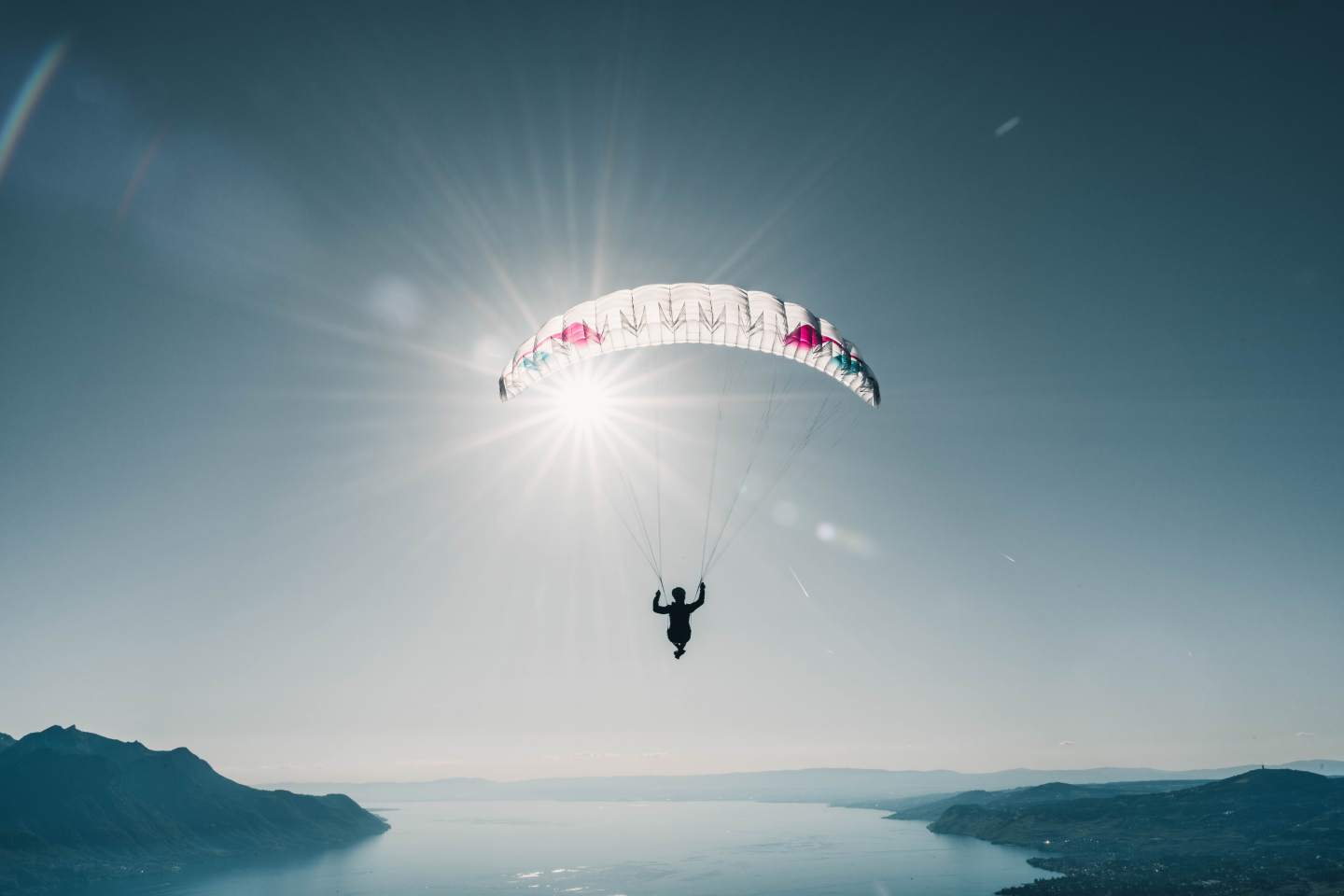 Pilote de parapente au décollage sur une crête de montagne, sac de portage sur le dos, une radio clipsée à la bretelle